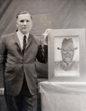 Albert K. Bender posing with a sketch of an MIB.
